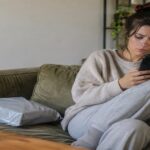 Frustrated young shopper checking her phone beside a fast-fashion poly mailer