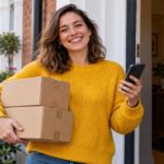 A person at a UK front door holding two parcels and a phone, comparing an Evri and a DPD delivery